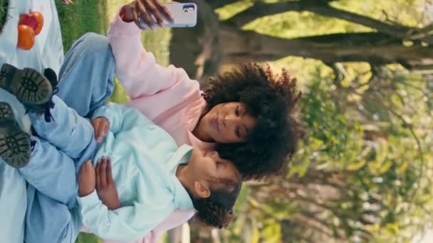 Lächelnde Mutter Die Mit Ihrer Tochter Mit Modernen Smartphone Vertikalaufnahmen — Stockvideo