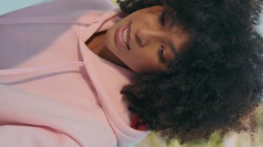 Anne kız doğada oturup güneşli hafta sonunun tadını çıkarıyor. Yakın çekim. Rahat Afro-Amerikan kadın portresi yeşil parkta küçük tatlı bir kızla konuşuyor. Mutlu aile dikey yönelimli rahatlıyor