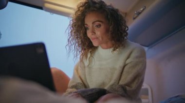 Dizüstü bilgisayarda e-posta okuyan kadın gezgin akşam karavanı kapanıyor. Gülümseyen kıvırcık kadın karavanda bilgisayar ekranına bakıyor. Orta yaşlı iş kadını hafta sonu kampta çalışıyor..