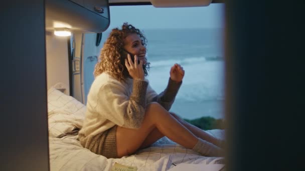 Akşam Okyanus Kıyısında Karavan Yatağında Cep Telefonuyla Konuşan Neşeli Bir — Stok video