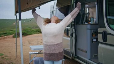 Neşeli bir kadın kamp alanında dinleniyor. Sabahın erken saatlerinde cesedi dışarı çıkarıyor. Yakınlaştırıyor. Tatilde kamp arabasının yanında duran kaygısız bayan gezgin. Kıvırcık kadın, hafta sonunun tadını çıkar.