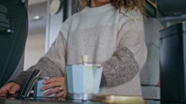 Moka demliğini tutan eller mutfakta aromatik sabah kahvesi hazırlıyor. Evdeki kahve makinesine süveter giymiş tanınmayan bir kadın taze arap ezmesi döküyor. Ev hanımı karavanda yemek pişiriyor..