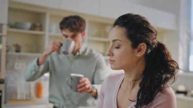 Modern apartman mutfağında birkaç kahvaltı işi var. Kapatın. Sevgi dolu koca, tablet bilgisayarlı güzel bir kadına kahve fincanı veriyor. Evde veda etmek için kadının yanağını öpen meşgul bir adam..