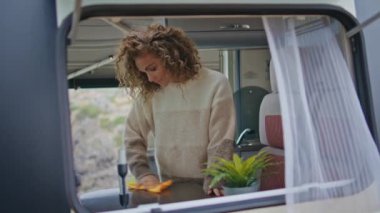 Bayan dans eden karavan mutfağı hafta sonu gezisinde temizlik yapıyor. Mutlu kadın, sonbahar tatilinin tadını çıkarırken karavan masasını bezle siliyor. Tasasız gezgin, karavan kampında rahatlarken mutluluğu hisseder..