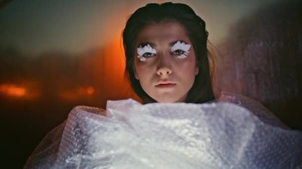 模型包裹的塑料垃圾反映生态友好的责任特写 一个有着创造性睫毛的神秘女人摆出黄昏的样子 在夜灯下 表演者被用泡沫包裹着 自然保护 — 图库视频影像