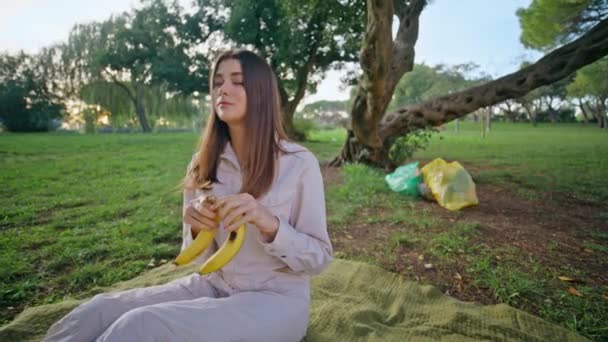 Piquenique Mulher Segurando Banana Relaxante Parque Cobertor Closeup Jovem Sorridente — Vídeo de Stock