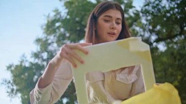 Odaklanmış kadın temizlik kirliliği. Parkta plastik torba kapanıyor. Kadın gönüllü, doğa korumasına olan bağlılığını göstermek için atık topluyor. Çevredeki çöplerle savaşan çevreci bir kız.