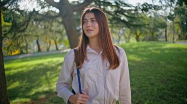 Sakin bir sabah güneşinin altında parktan zevk alan bir kadın. Serin yeşil doğada duran güzel genç kız dışarıda huzur buluyor. Serin yeşillikte kadın sükuneti..