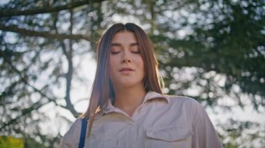 Yeşil Serene Park 'ta elinde elma tutan düşünceli bir kadın. Güneşli doğada taze meyvelerle poz veren güzel kadın modelinin portresi. Sakin ve düşünceli, çekici bir kadın..