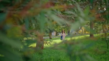 Huzurlu bir kadın yeşil parkta yürüyor. Huzurlu kız yaz haftasonunda doğa huzurunun tadını çıkarıyor. Sıradan tarz bir kadın, yemyeşil çimlere basıyor. Kaygısız bayan sakin, gezgin, güzel bahçe..