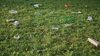 Çevresel ihmalkarlığın göstergesi olarak park çimlerini kirleten çöpler. Çöpe atılmış plastik şişeler ve atıklar kentsel ekolojik sorunlar yaratıyor. Yeşil doğayı bozan dikkatsiz kirlilik kamu alanı. 