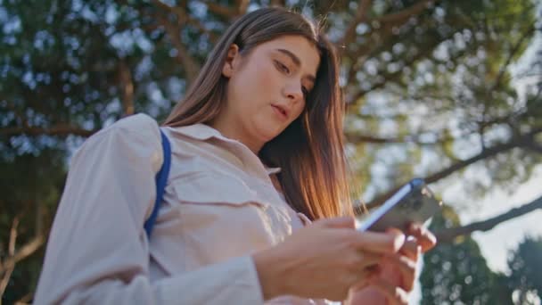 Thoughtful Girl Absorbed Smartphone Browsing Sunny Park Closeup Serious Young — Stock Video