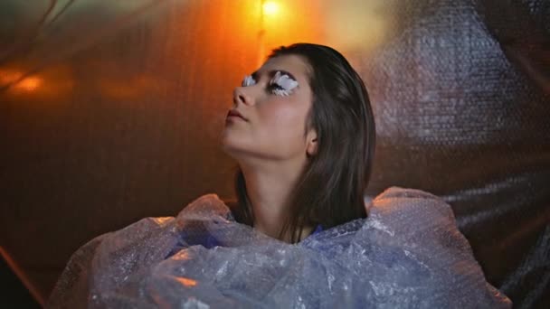 Μόδα Γυναίκα Πέταλο Μακιγιάζ Περιβάλλεται Από Ανακλαστική Φούσκα Wrap Closeup — Αρχείο Βίντεο