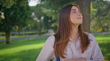Düşünceli bir kadın su tutuyor ve lüks bir parkta sakin bir anın tadını çıkarıyor. Yeşil doğada düşüncelere dalmış sakin bir portre kızı. Yeşil bir çevrede limon içen barışçıl bir bayan..