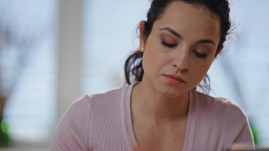 Kadın serbest çalışan not defterine not alıyor. Ev ofisini kapatıyor. Modern dizüstü bilgisayarda çalışan güzel, ciddi bir kız not defterine yazı yazıyor. Dairede kompozisyon oluşturan odaklı kadın yazar