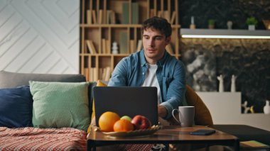 Adam dizüstü bilgisayarını bitirip oturma odasındaki kanepeye oturur. Modern bilgisayarı kapatan genç serbest çalışan yorgun ve kahve molası veriyor. Ciddi iş adamları iş meselelerini uzaktan çözer..