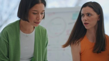Bakanlar Kurulu 'nda birlikte çalışan odaklanmış kadınlar. Kafası karışmış bir bayan iş arkadaşlarına soruyor. Genç yaratıcı ekip ofiste iş projesini tartışıyor. İş arkadaşları dizüstü bilgisayarla not yazıyorlar.