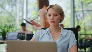 Dizüstü bilgisayarda çalışan iş kadını ofis kapanışı. Sakin bir iş kadını modern işyerinde kahve fincanını yudumluyor. Yoğunlaştırılmış ciddi kadın bilgisayar ekranına bakıyor ve birlikte çalışmakla meşgul.