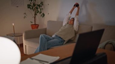 Dinlenen kadın, akşam kanepesinde tek başına uzanıyor. Rahat bir kadın elinde cep telefonuyla koltuğun içinde keyfine bakıyor. Geç kalmış iş kadını işten sonra mum ışığında duraklıyor.