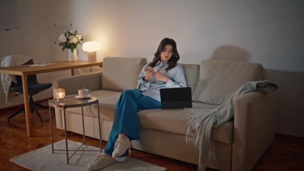 Relaksująca Kobieta Przeglądająca Smartfony Wnętrzu Wieczornej Sofy Spokojna Kobieta Freelancer — Wideo stockowe