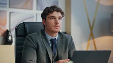 Lüks ofislerde dizüstü bilgisayarı olan ciddi bir CEO masası. Uzağa bakan düşünceli girişimci bilgisayar masasına odaklanmış hissediyor. Esmer iş adamı kabinede iş yapmayı düşünüyor 