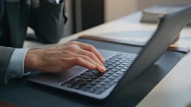 Masa başında klavye kapama dizüstü bilgisayarı yazan adam parmakları. Ajansın ofisinde bilgisayar işini bitirmekten yoruldum. Mutsuz, aşırı çalışan patron modern kabinede tapınakları tek başına ovuyor. 