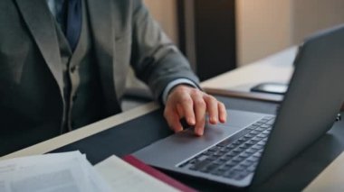 Ofis masasında belgeleri inceleyen bir adam var. Odaklanmış şirket yöneticisi dizüstü bilgisayarı hazırlıyor not defterindeki bilgileri kontrol ediyor. Heyecanlı iş adamı kazananı masada seviniyor.