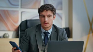 Ofis kapanışında cep telefonu tebligatını okuyan heyecanlı yönetmen. Cep telefonu ekranını izleyen neşeli adam iş yerinde başarıya seviniyor. Mutlu iş adamı duygusal açıdan başarılı.