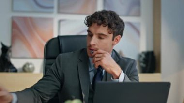 Kapalı ofis yöneticisi çözüm arama mesafesini düşünüyor. Modern kabinede kalem üzerinde kafa yoran ciddi bir adam. Başarılı bir iş adamı dizüstü bilgisayarla içeride toplantı bekliyor. 