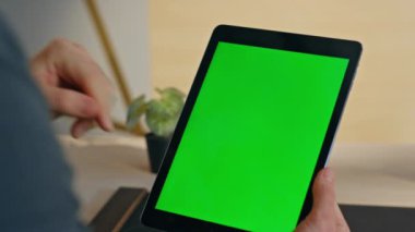Modern iş yerinde yeşil ekran tabletine dokunan adam parmağı. Bilinmeyen yönetici, kapalı alanlarda internet arama verilerini kullanıyor. İş adamının el yapımı dijital aygıtı yaratıcı ajansdan aşırması