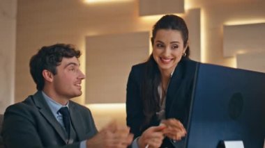 Mutlu meslektaşlar sürpriz yaparak yakın planda başarıyı kutladı. Gülümseyen tüccarlar bilgisayarda başarılı borsa verilerini kontrol ediyorlar. Memnun iş adamları beş veriyor.