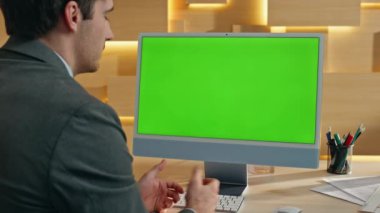 Modern ofiste Greenscreen PC 'den özel ders toplantısı. Arkadaş canlısı bir yönetici bilgisayar kamerasına el kol hareketi yapıyor. İş adamının iş videosu Chroma Key Gadget tarafından kapalı mekanda dinleniyor. 