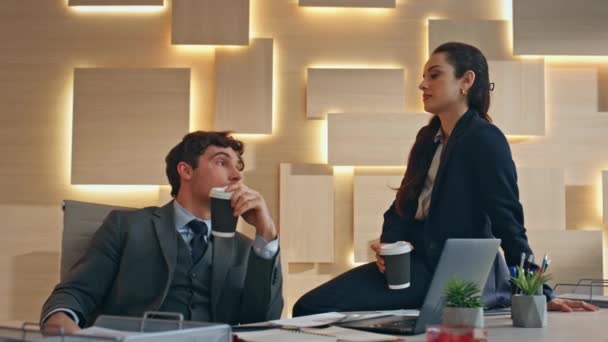 ビジネスカップルは 夜のオフィスのクローズアップでコーヒーを飲む ベージュキャビネットでカプチーノと休憩室を楽しむリラックスした企業労働者 非公式な雰囲気の同僚 — ストック動画