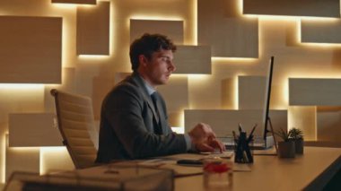 Çok çalışan adam, gece geç saatlerde ofis kapanışında akıllı telefonu kontrol ediyor. Yorgun iş adamı gece ajansında gözlerini ovuşturuyor. Endişeli yönetici kabinede mola veriyor. 