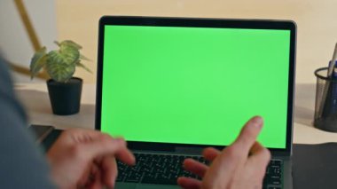 Kimliği belirsiz bir adam yeşil ekran laptopunda video görüşmesi yapıyor. Tanımlanamayan yönetmen bilgisayar başında konuşuyor. Patron Chroma Key yaratıcı ajansında sanal konferans yapıyor. 