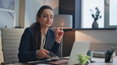 Buro kapanışında akıllı telefondan kötü mesaj yazan hayal kırıklığına uğramış bir kadın. Hayal kırıklığına uğramış iş kadını ofis masasında başarısız olduğu için üzgün olarak bilgisayarını kapattı. Sinirli, stresli, işini bitiren kadın sorunlardan memnun değil. 