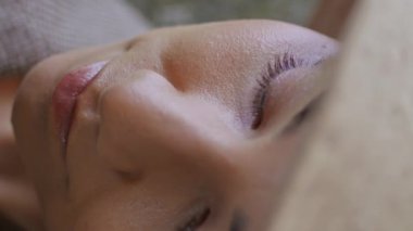 Kapanış kızı üzüm bağında üzüm demeti tutuyor. Açık havada dikey çekilen olgun çileklere bakan çekici genç bayan portresi. Gülümseyen kadın kameraya bakıyor Panama 'nın altında saklanıyor asma tarlasında.