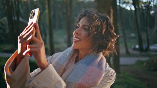 Frau Reisenden Fotografiert Sonnigen Wald Auf Handy Mit Unbeschwertem Lächeln — Stockvideo