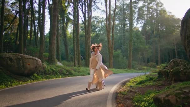 スーツケースで秋の夜に森の道を歩いている自信のある少女 グリーンウッドランドの道を一人で歩くスタイリッシュな女性探検家 バケーション旅行で自然の自由を楽しむ美しい女性のワンダー — ストック動画