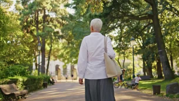 Пожилая Женщина Наслаждается Прогулкой Зеленом Парке Отдых Одиночестве Прогулка Городскому — стоковое видео