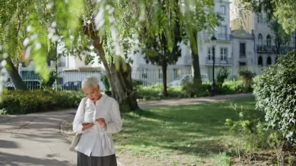 Μεγαλύτερη Γυναίκα Γραπτών Μηνυμάτων Κινητό Τηλέφωνο Στο Ηλιόλουστο Καλοκαιρινό Πάρκο — Αρχείο Βίντεο