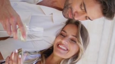 Mutlu yeni evliler romantik randevusu Sunshine Terasta yakın çekim. Yaz tatilinde şampanya içip gülen rahat aşıklar. Şarap kadehlerini dikey olarak gösteren neşeli bir çift. Karı koca yıldönümünün tadını çıkarın.