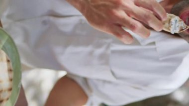 İtalyan esmer, kafe terasında aperatif yiyor. Lübnan geleneksel Pita ekmeği tatmakta olan yakışıklı ve traşsız bir adam. Humus ve doğu mutfağının dikey manzarasının tadını çıkarıyor. Restoranda maço yemeği.