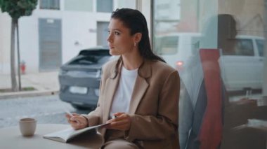 Kafe 'de oturan düşünceli serbest yazar defteri kapat. Fotokopi defterine not alan düşünceli kadın yazar kafeteryada ilham alıyor. Göz kamaştırıcı iş kadını günlükte çalışma programı yaratıyor.