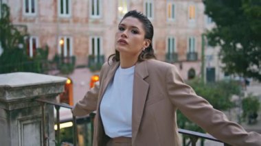 Kaygısız kız şehir sokaklarında dinleniyor metal korkuluklara yaslanıyor. Alacakaranlık Mahallesi 'nde şık bir takım elbise giyerek poz veren kendine güvenen bir kadın model. Kasabada duran çekici bayan, hafta sonunun tadını çıkarın..
