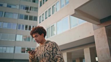 Akıllı telefondan gelen ses kaydını kaydeden adam kapalı bir yerleşim alanında. Kıvırcık İspanyol adam şehir binalarında cep telefonundan sesli mesaj yaratıyor. Genç hippi dışarıda telefon kullanıyor..