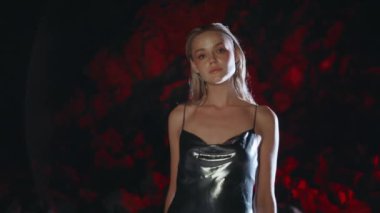 Profesyonel model gece kayalıklarında poz veriyor. Projektör ışığı içinde harika bir kız parti elbisesi içinde kamera çekimine benziyor. Seksi baştan çıkarıcı sarışın yaz festivalinde karanlık kıyıda duruyor. Gece hayatı kadın konsepti