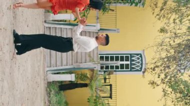 Birkaç samba dansçısı dikey yolda enerjik danslar yapıyor. Açık havada Latin tarzı dans eden profesyonel sanatçılar. Güzel İspanyol esmer kadın çekici bir adamla baştan çıkarıcı bir şekilde hareket ediyor..