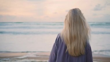 Okyanus kızı güzel gökyüzüne yakından bakıyor. Huzurlu bir kadın akşam deniz kenarında dikiz aynasından yürüyor. Seyahat modeli köpüklü dalgaları düşünerek kayalık sahilde hayal kuruyor. Sakin kadın dinleniyor yaz kıyısı