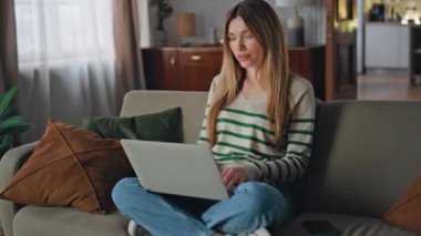 Kanepe oturma odasında dizüstü bilgisayar kullanan rahat bir bayan. Sakin, güzel bir kadın akıllı telefon ekranına bakıyor ve evde mesaj alıyor. Düşüncesizce internette gezinen genç bir kız tasasız bir hafta sonu dairesinde